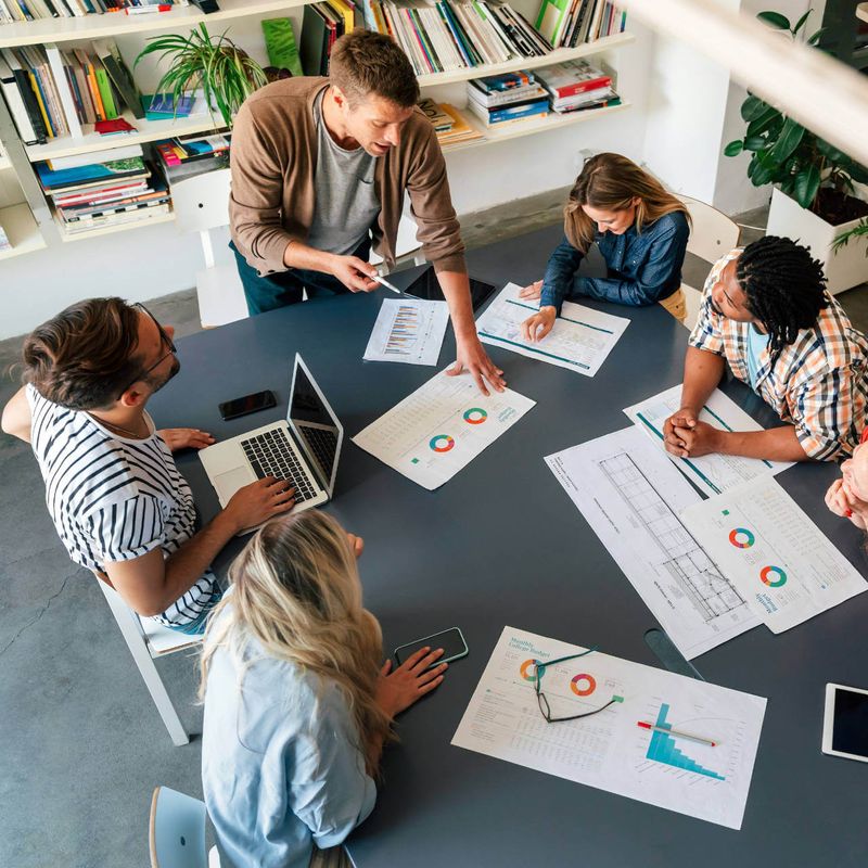 A group of people analyzing graphs at a table.