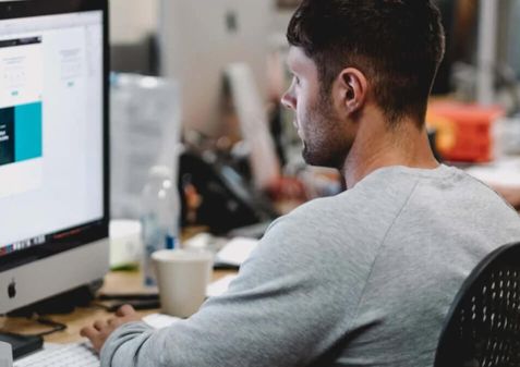 A person sitting at a desk and working on a computer.