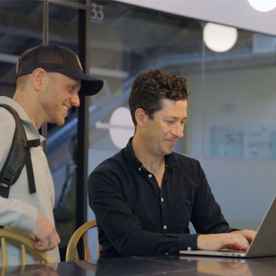 Deux personnes travaillant ensemble sur un ordinateur portable.